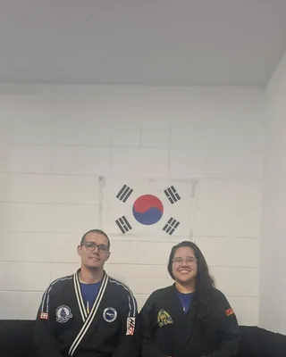 Prof. Henrique Morato de dobok, no dojô, sob a bandeira da Coreia