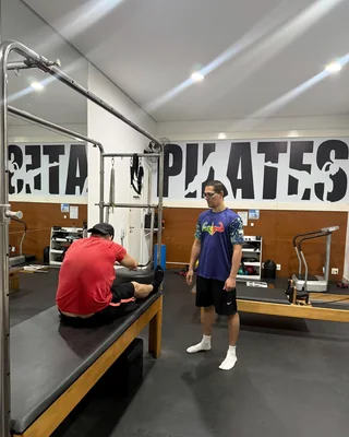 Prof. Henrique Morato conduzindo uma aula de Pilates no reformer, em Praia Grande